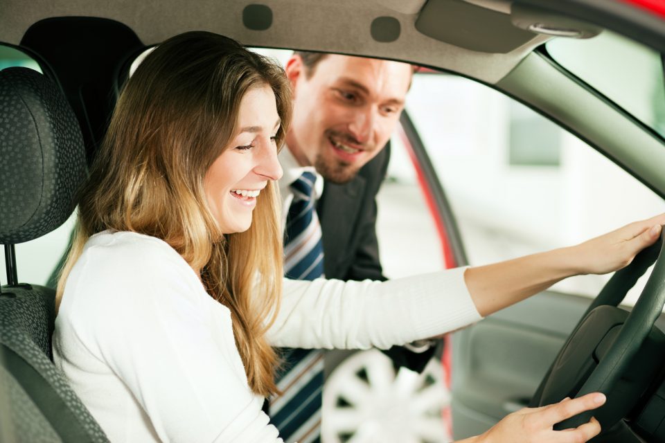 Close-up of woman in car with car salesman