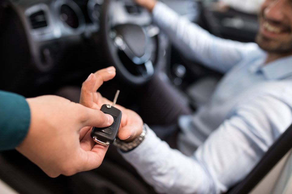 Close up of a man receiving new car key.