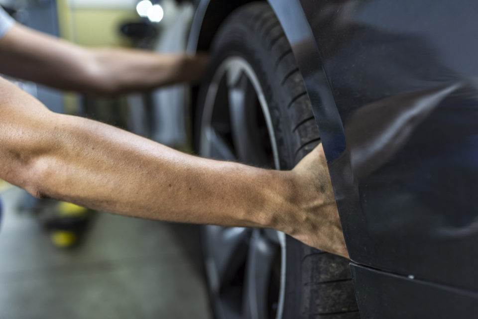 Hands of mechanic changing a wheel of a modern car